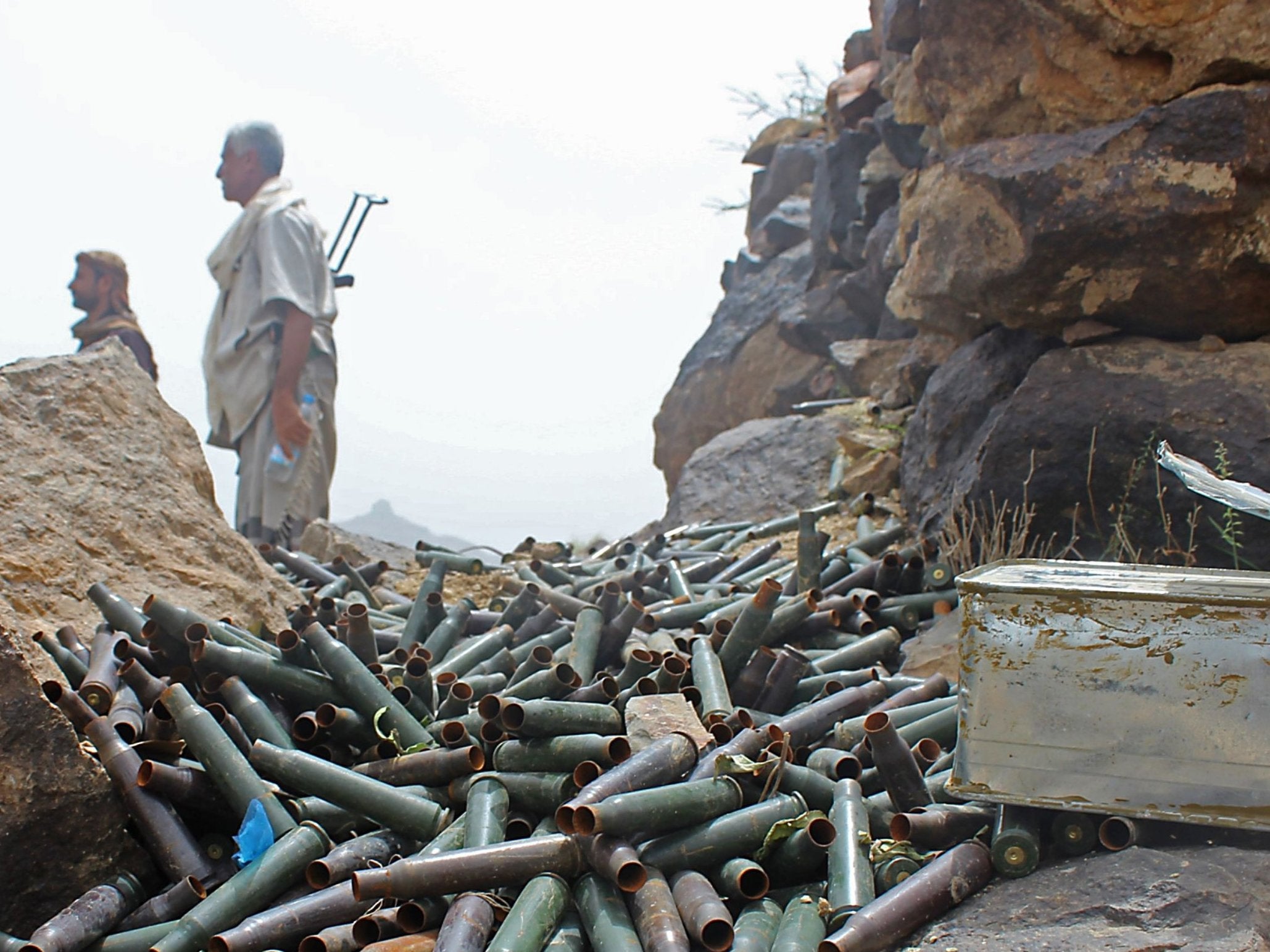 Yemeni pro-government fighters stand by cartridge cases as Saudi- and Emirati- supported forces take over Houthi bases on the frontline of Kirsh between the province of Taez and Lahj, southwestern Yemen