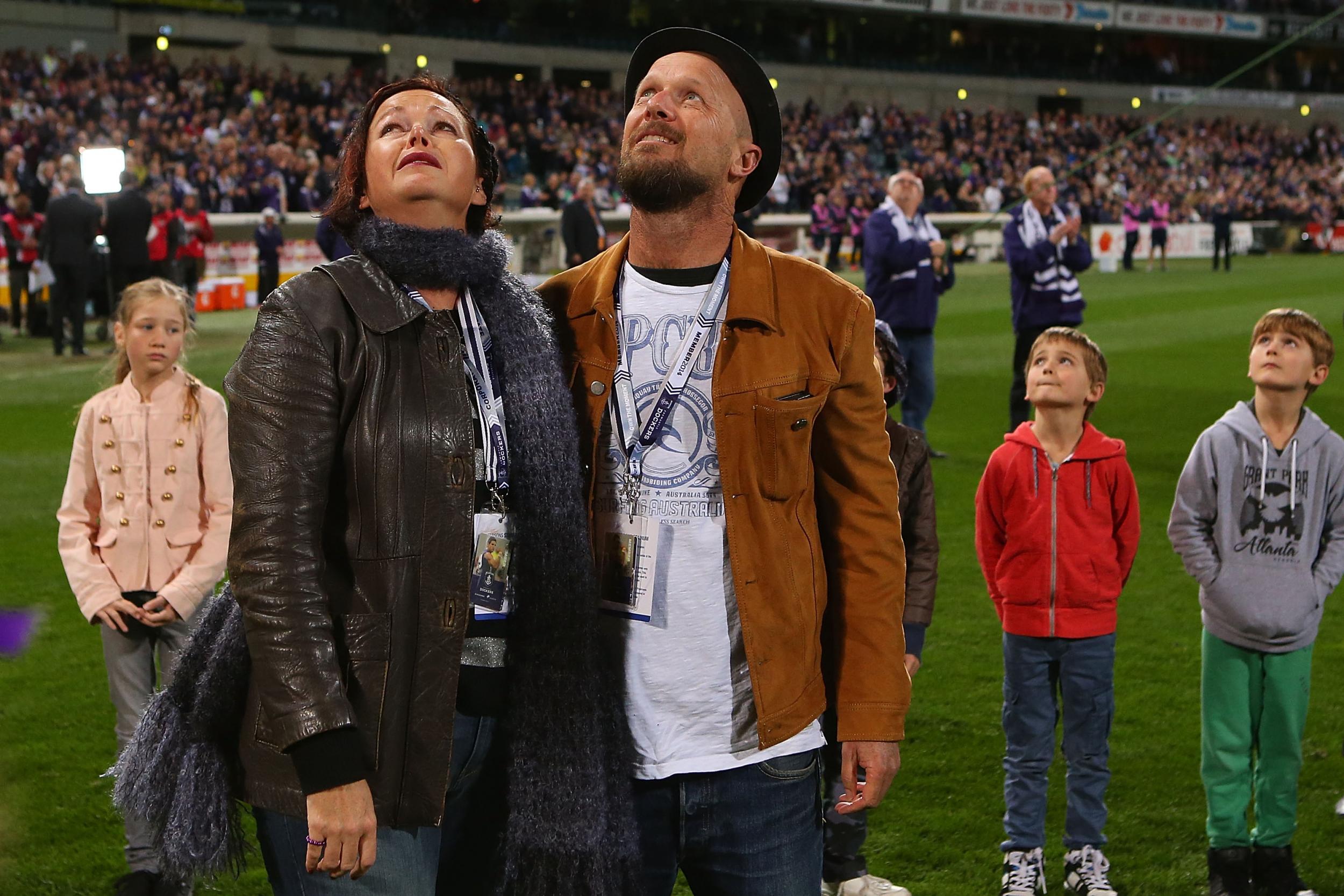 Rin Norris and Anthony Maslin look on after releasing balloons in tribute to their children at an Australian rules football match in Perth in July 2014