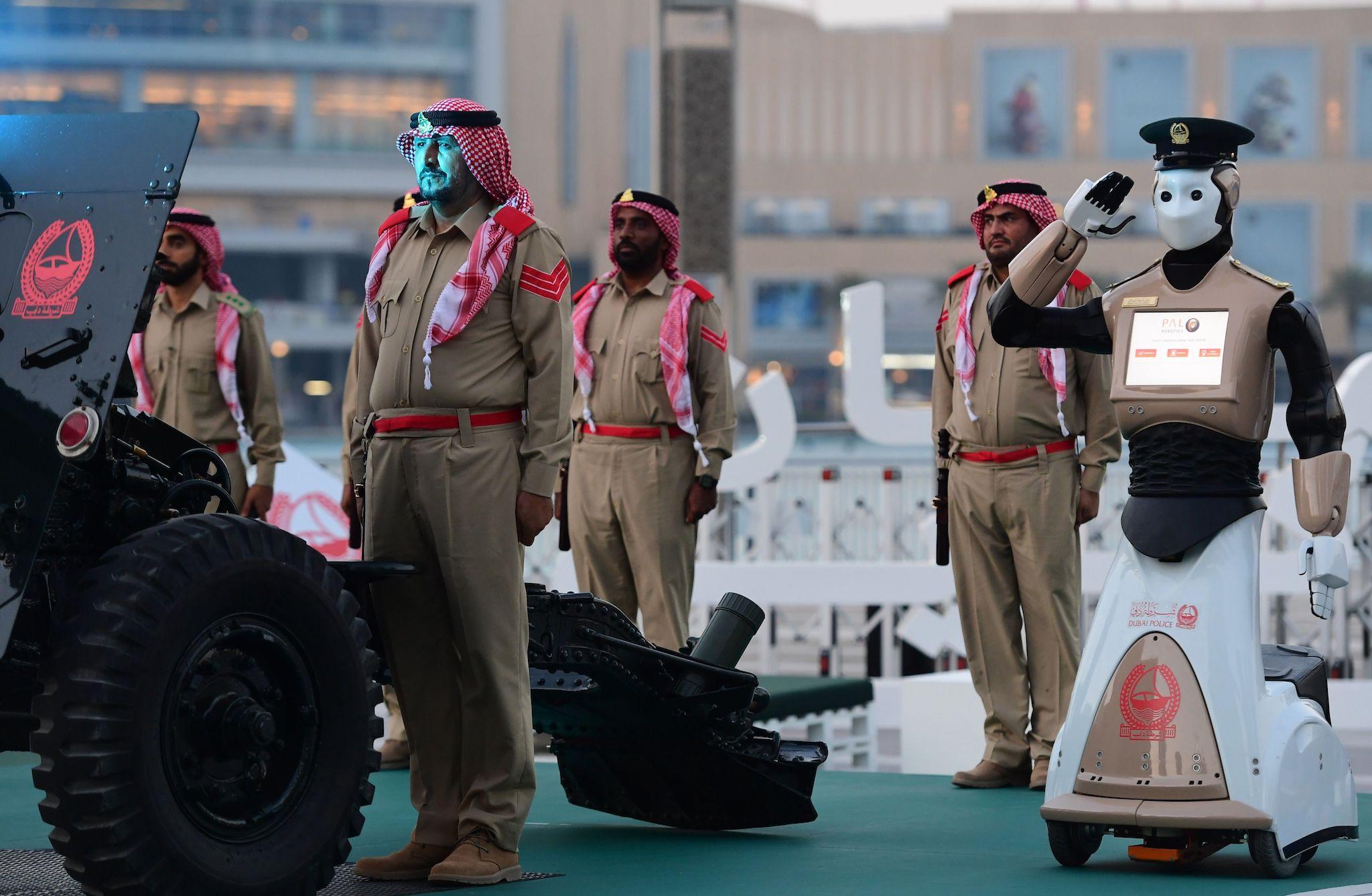 The world's first operational police robot stands at attention as they prepare a military cannon to fire to mark sunset and the end of the fasting day for Muslims observing Ramadan, in Downtown Dubai on May 31, 2017