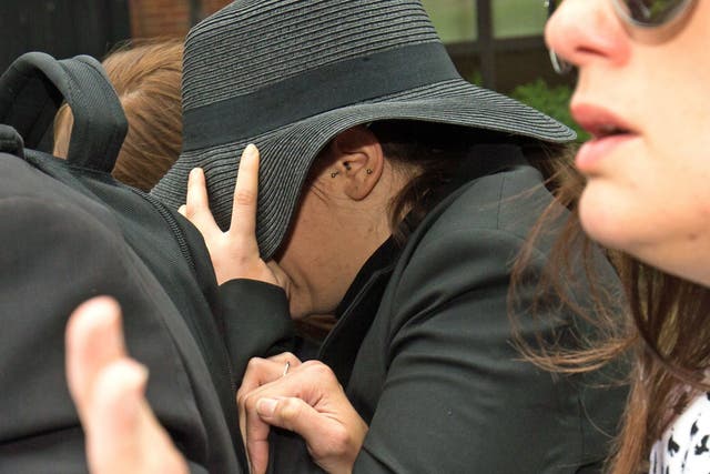 Hiding behind a black hat, Lauren Leigh leaves Nottingham Magistrates' Court where she was acquitted of of racially-aggravated harassment.