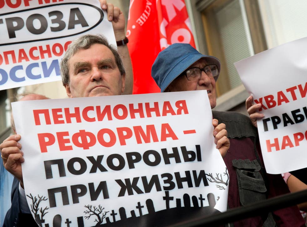 People hold posters reading from ‘Pension reform is a funeral in life, Stop robbing people’ during a demonstration yesterday in front of the Russian State Duma in Moscow