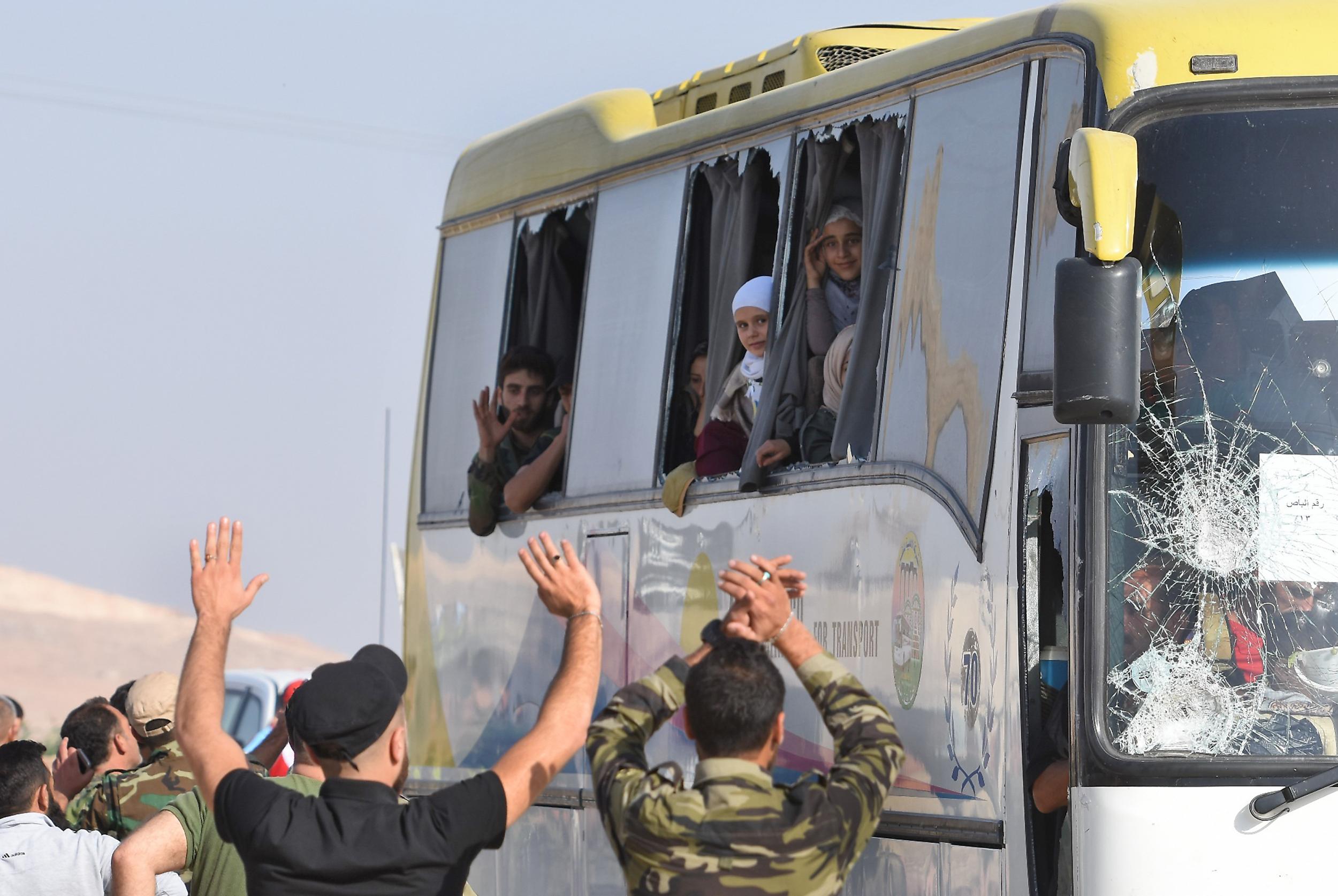 Buses transporting residents and fighters from the towns of Fuaa and Kefraya arrive in the Syrian regime-held territory at the al-Eis crossing point south of Aleppo on Thursday