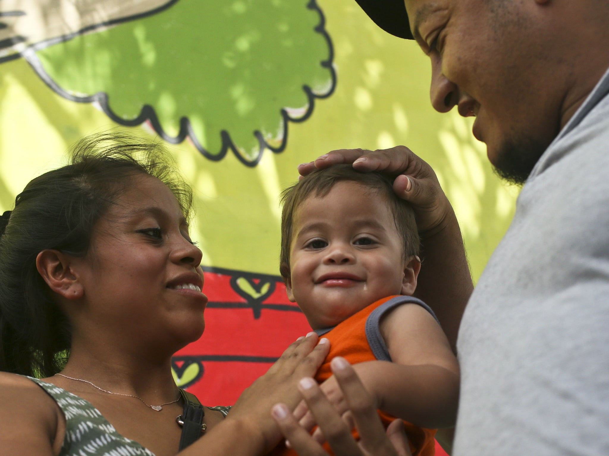 Adalicia Montecino holds her year-old son Johan Bueso Montecinos, who became a poster child for the US policy of separating immigrants and their children, as his father Rolando Bueso Castillo caresses Johan's head