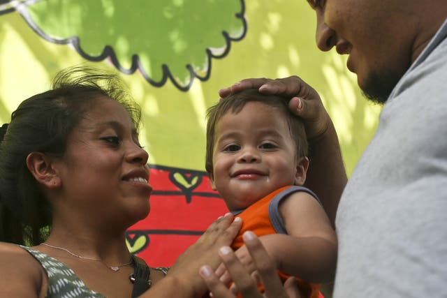 Adalicia Montecino holds her year-old son Johan Bueso Montecinos, who became a poster child for the US policy of separating immigrants and their children, as his father Rolando Bueso Castillo caresses Johan's head