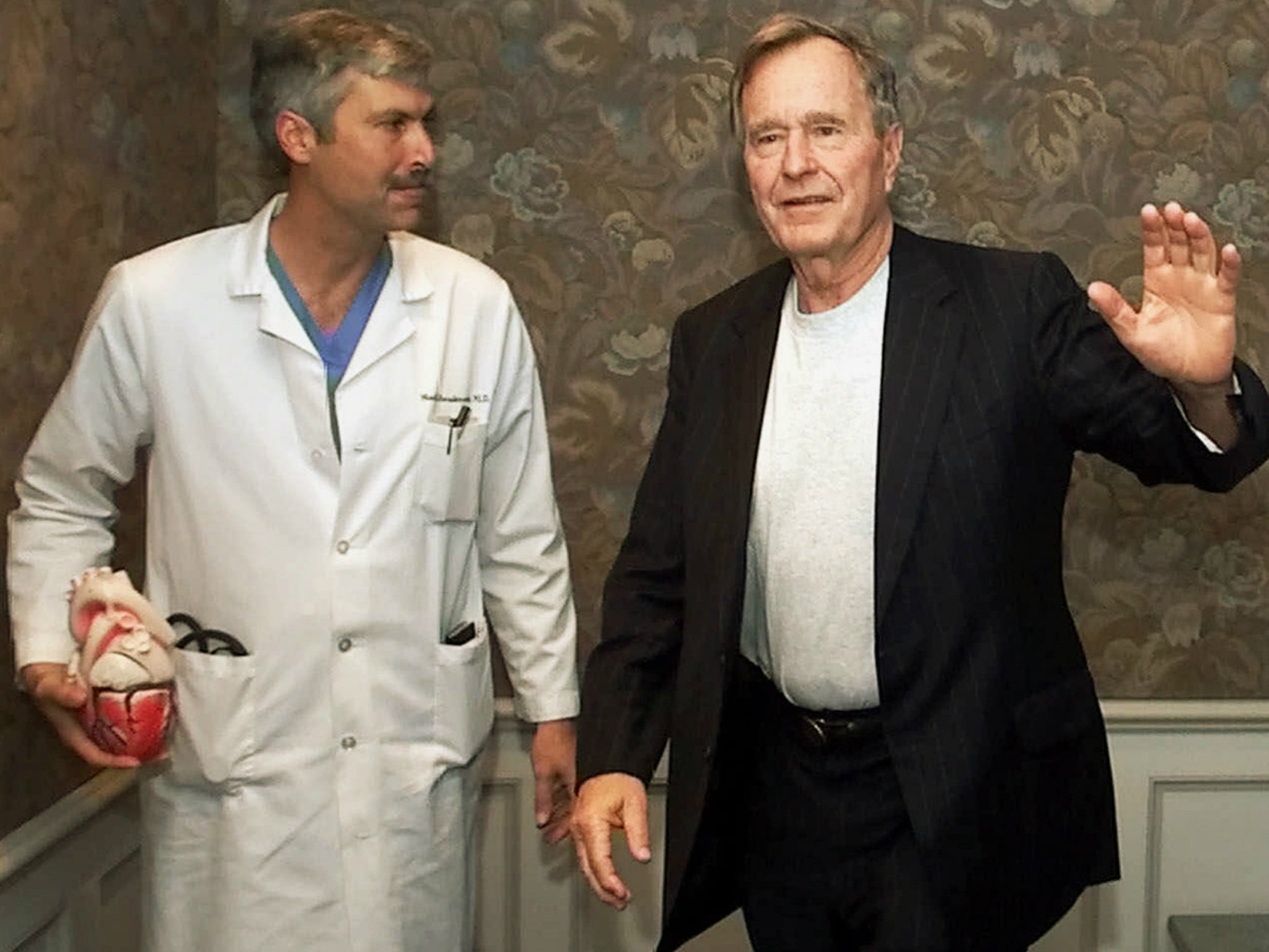 In this 25 February 2000 file photo, former President George HW Bush waves as he leaves Methodist Hospital with his cardiologist, Mark Hausknecht, who was killed in a bicycle drive-by shooting on 20 July 2018.