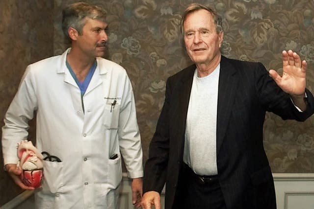 In this 25 February 2000 file photo, former President George HW Bush waves as he leaves Methodist Hospital with his cardiologist, Mark Hausknecht, who was killed in a bicycle drive-by shooting on 20 July 2018.