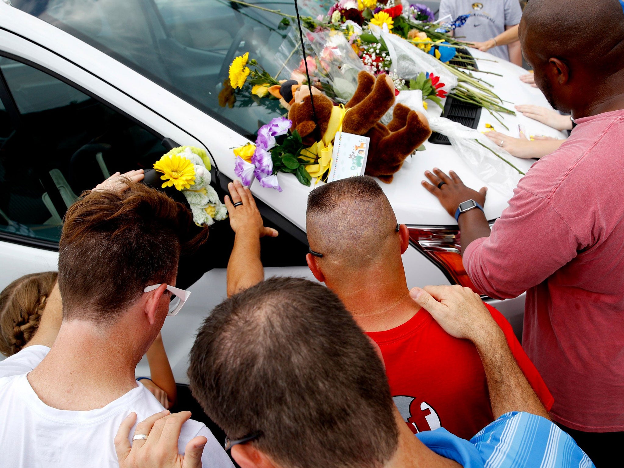 The victims’ cars, left in a nearby parking lot ahead of the tour, were adorned with flowers, stuffed animals, balloons and handwritten notes expressing condolences