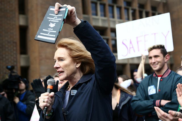 Seattle Mayor Jenny Durkan holds a copy of the US Constitution while speaking at a gun control reform protest on 14 March 2018. She was recently named in a lawsuit by the National Rifle Association