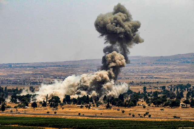 Quneitra in Syria viewed from the Israeli-annexed Golan Heights – smoke rises as rebels destroy their arms stocks prior to their departure