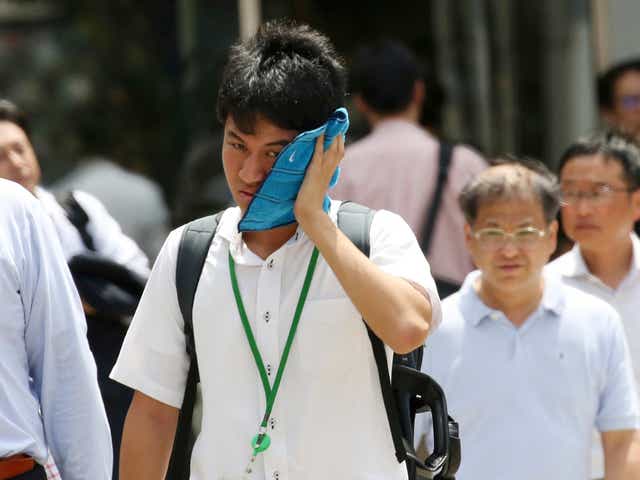 <p>A man wipes the sweat from his face in the scorching heat at a business district in Tokyo</p>