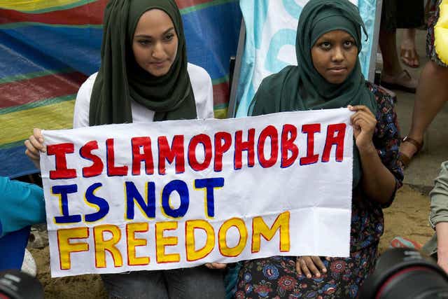Two women hold a sign at an anti-Islamophobia protest