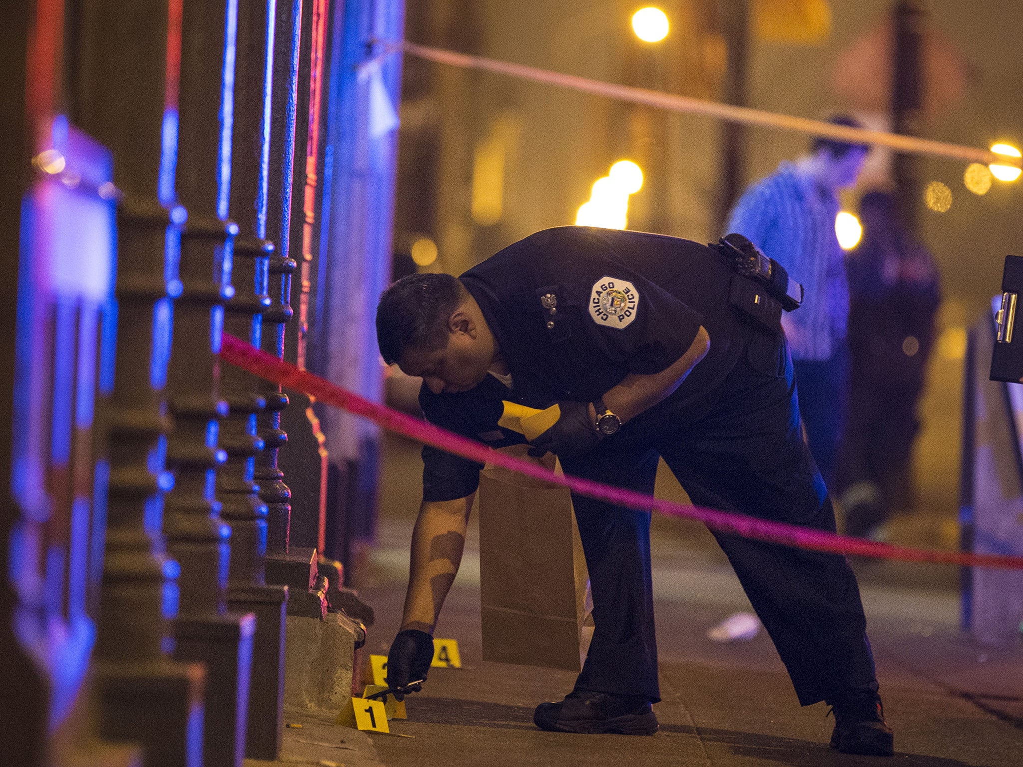 A Chicago police officer collects evidence at a crime scene. Chicago, with 2.7 million people, is the most violent large city in the US