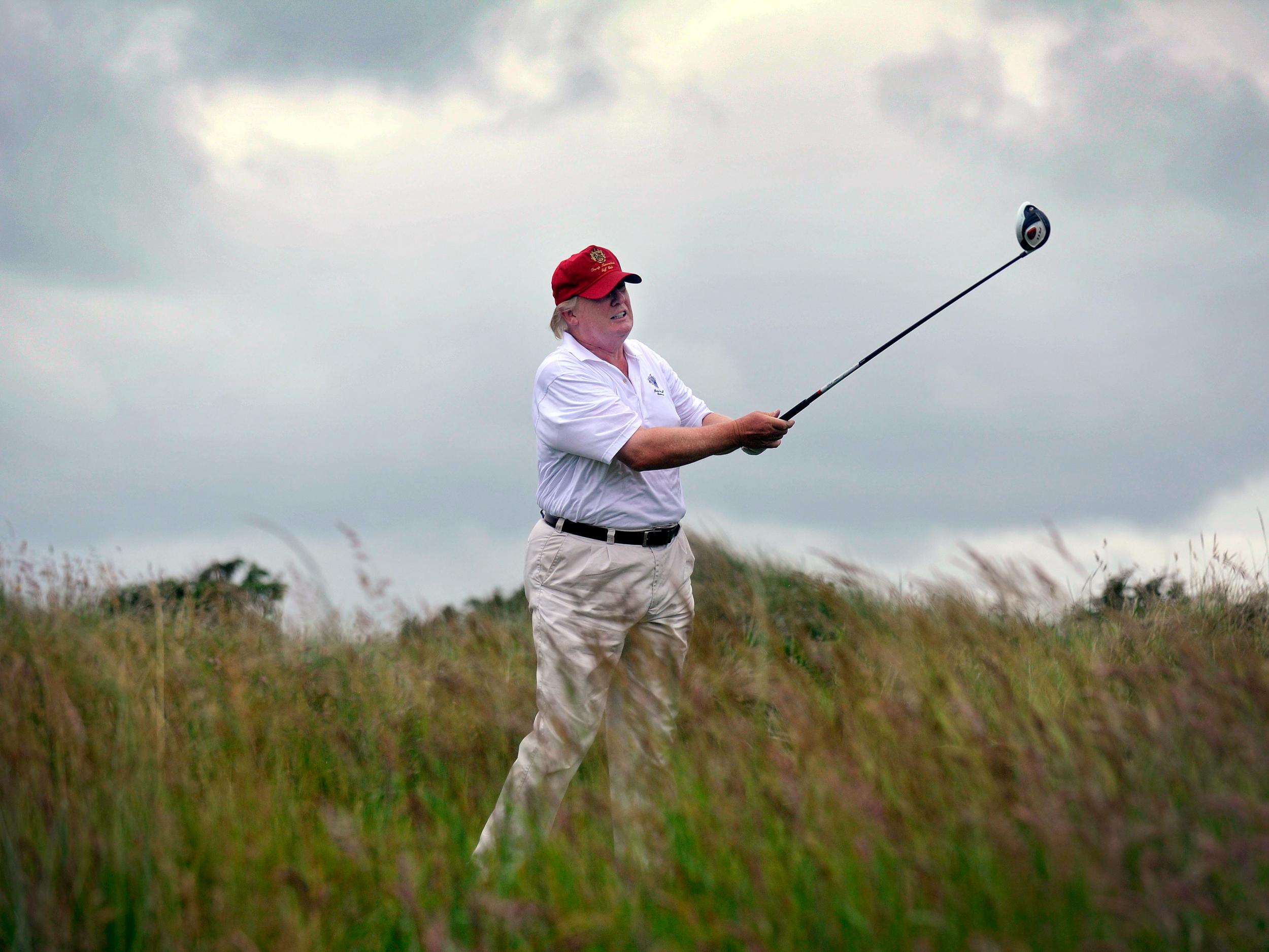 Donald Trump plays a stroke as he officially opens his new multi-million pound Trump International Golf Links course in Aberdeenshire, Scotland, on 10 July 2012