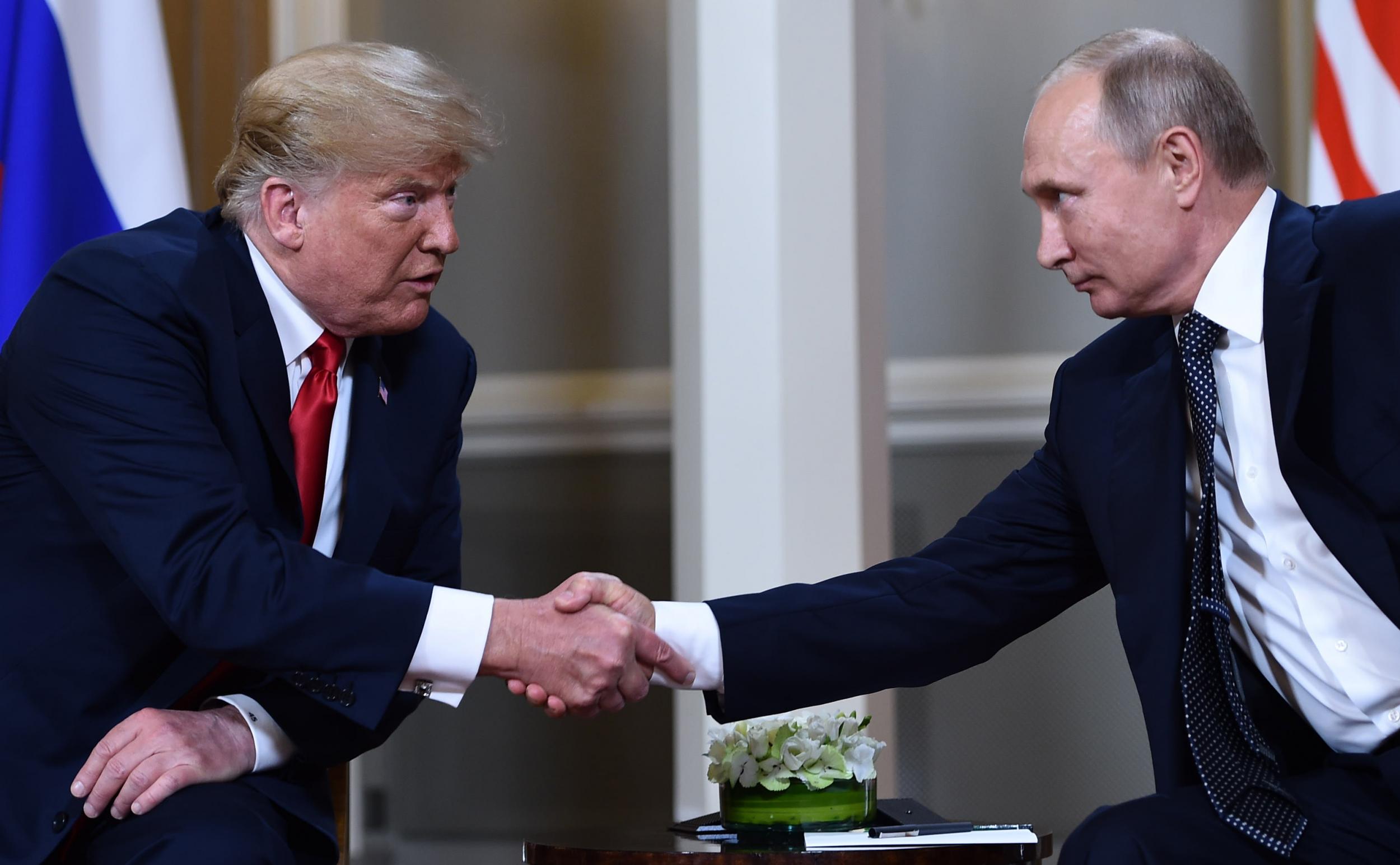 Russian President Vladimir Putin and US President Donald Trump shake hands before a meeting in Helsinki