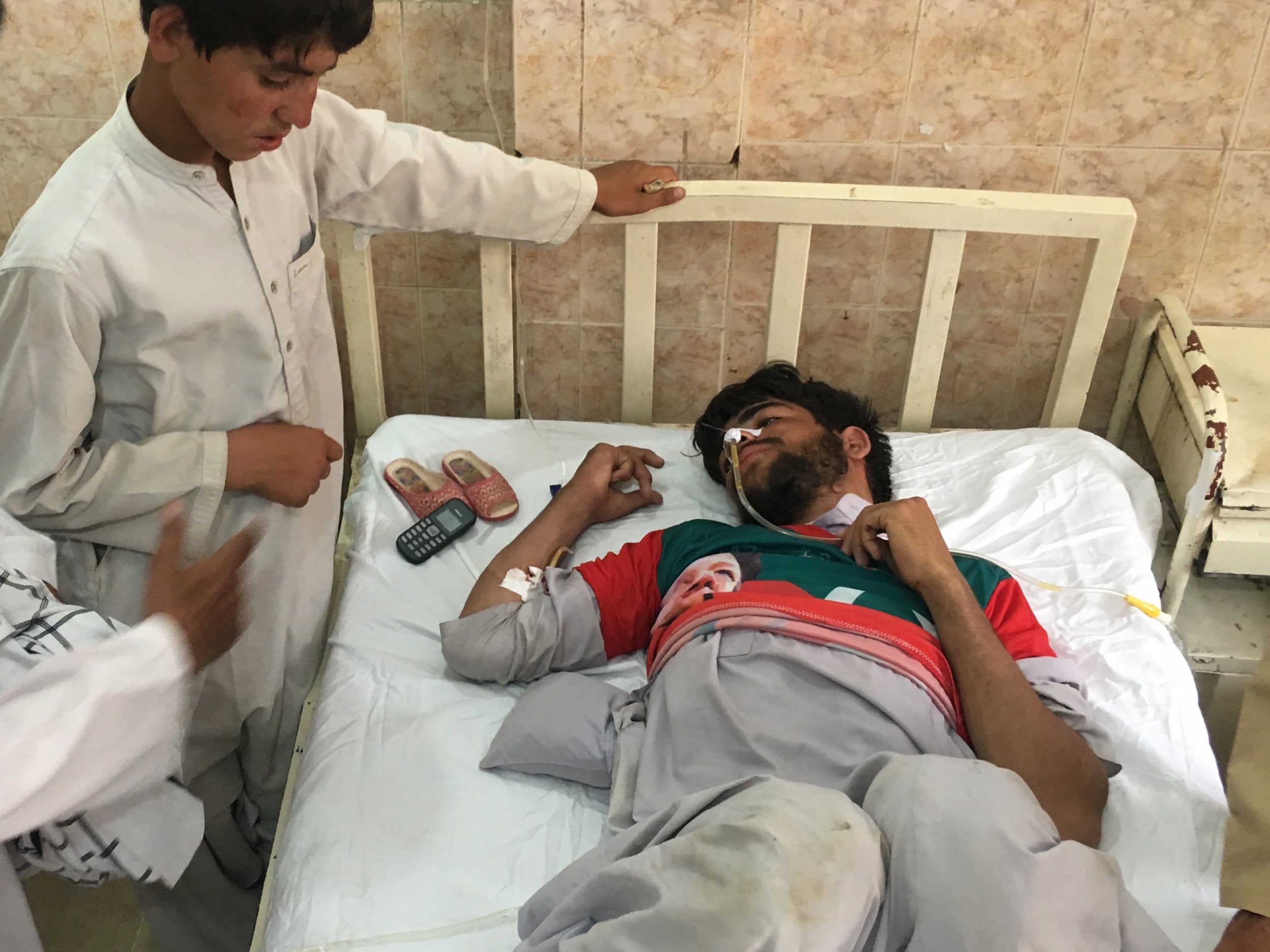A man who was injured in a suspected suicide bomb attack outside a polling station in Quetta receives medical treatment