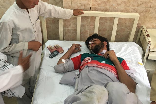 A man who was injured in a suspected suicide bomb attack outside a polling station in Quetta receives medical treatment