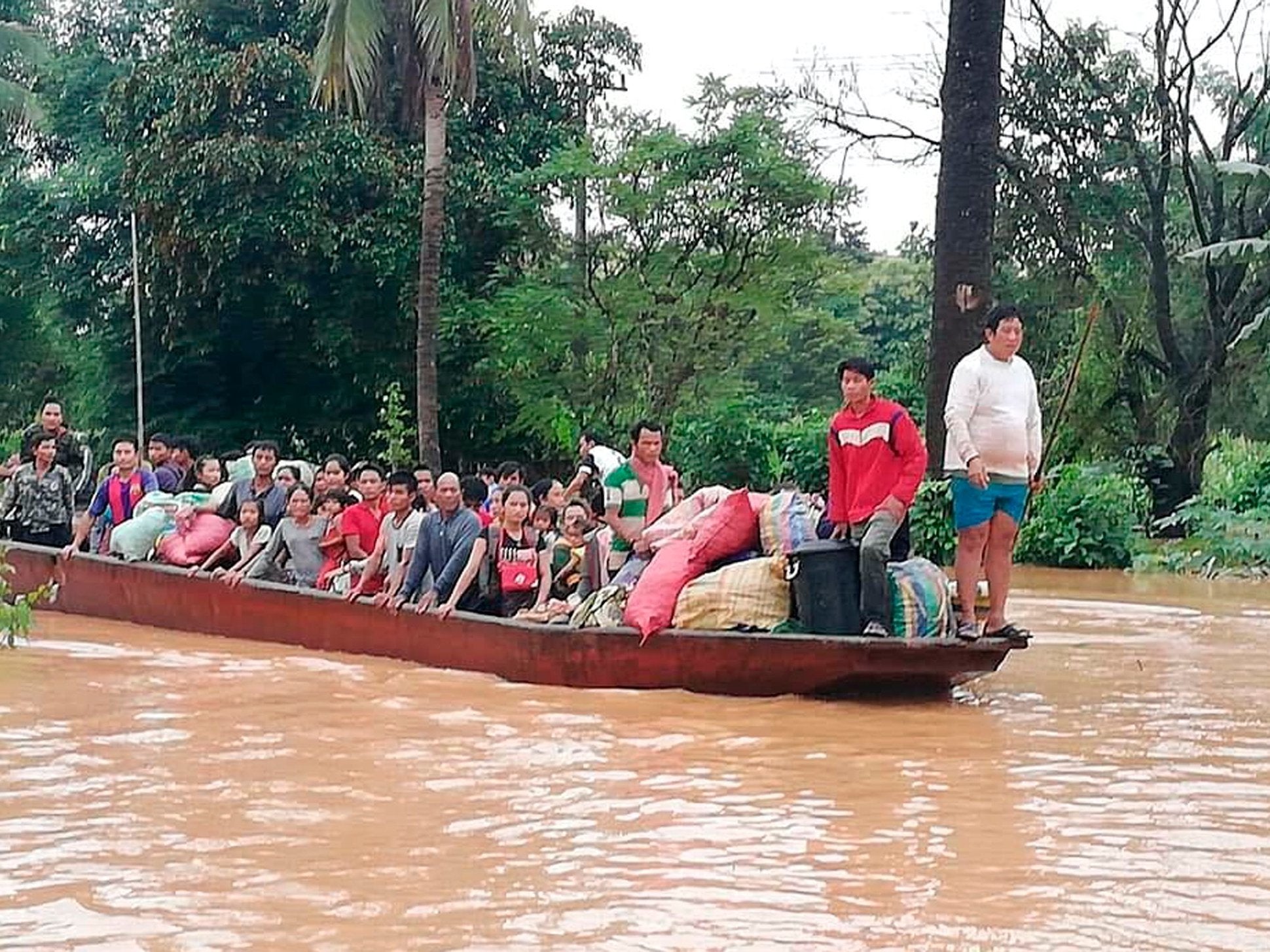 People are evacuated from floodwaters on a boat