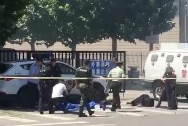 Videos posted to social media showed police surrounding a white car and a number of objects scattered across the ground