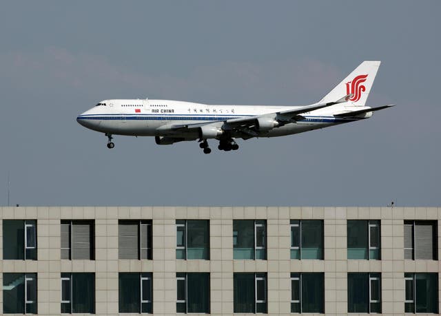 An Air China flight lands at the Beijing Capital Airport near Langham Place Hotel (foreground), China October 2, 2010.