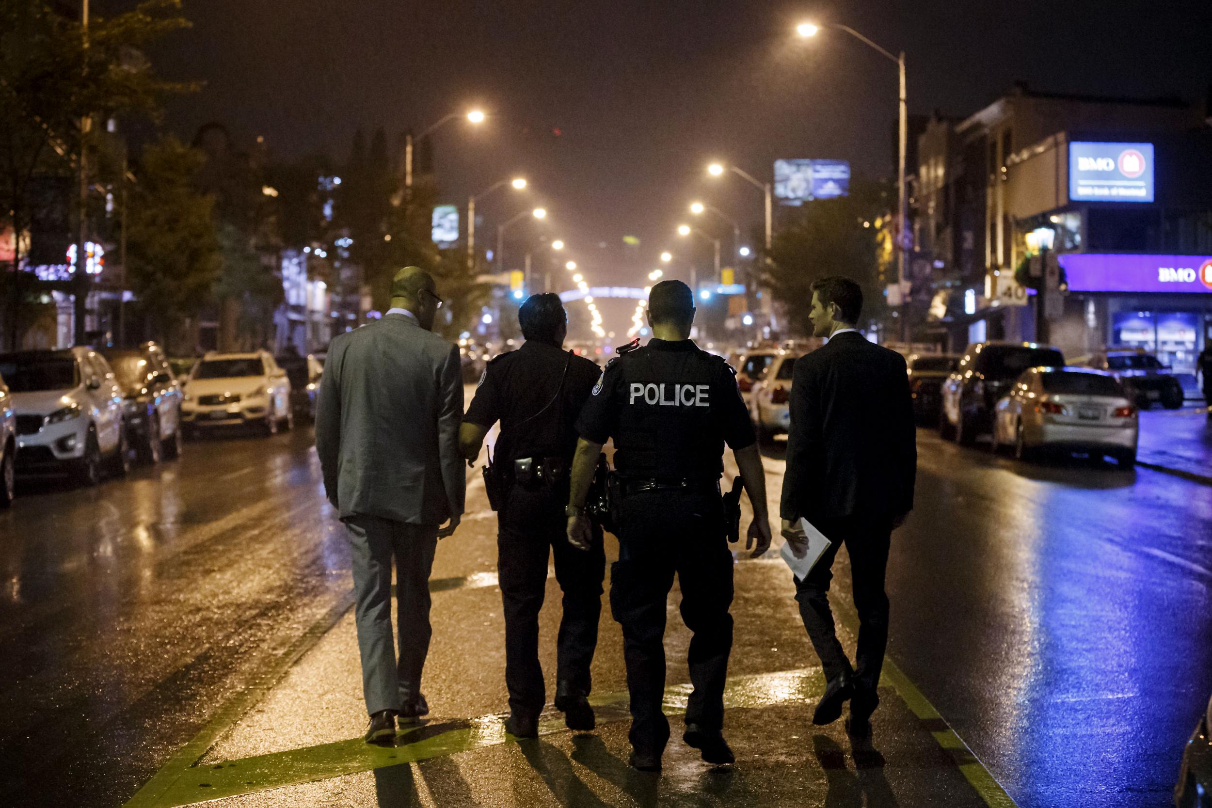 Toronto Police officers work on Danforth St., at the scene of a shooting in Toronto, Ontario