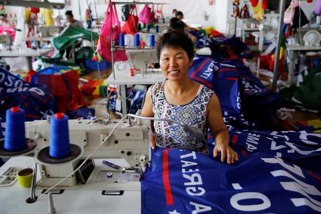 A worker poses for pictures as she makes flags for U.S. President Donald Trump's "Keep America Great!" 2020 re-election campaign at Jiahao flag factory in Fuyang, Anhui province, China July 24, 2018.
