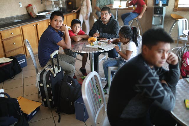 Nery (L) and Emiliano (2nd R) sit with their children as they are cared for in an Annunciation House facility after they were reunited
