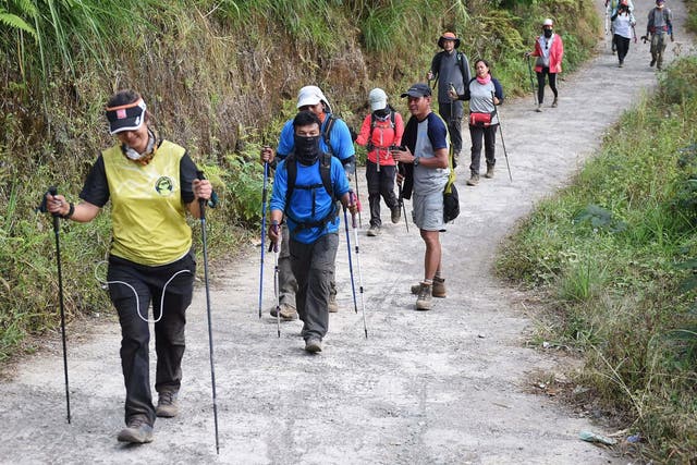 Indonesian and foreign climbers walk down from Mount Rinjani at Sembalun village in Lombok, Indonesia