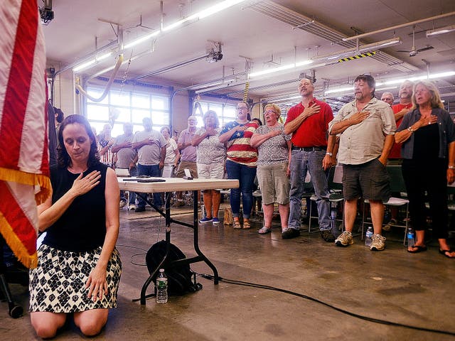 Melissa Schlag kneels for the Pledge of Allegiance during a Haddam board of selectmen meeting on Monday, 30 July