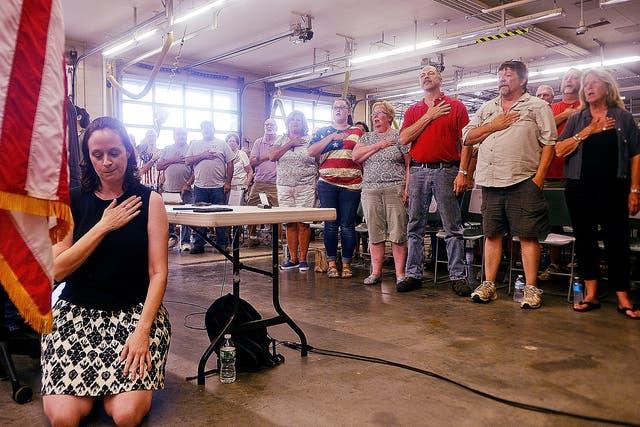 Melissa Schlag kneels for the Pledge of Allegiance during a Haddam board of selectmen meeting on Monday, 30 July