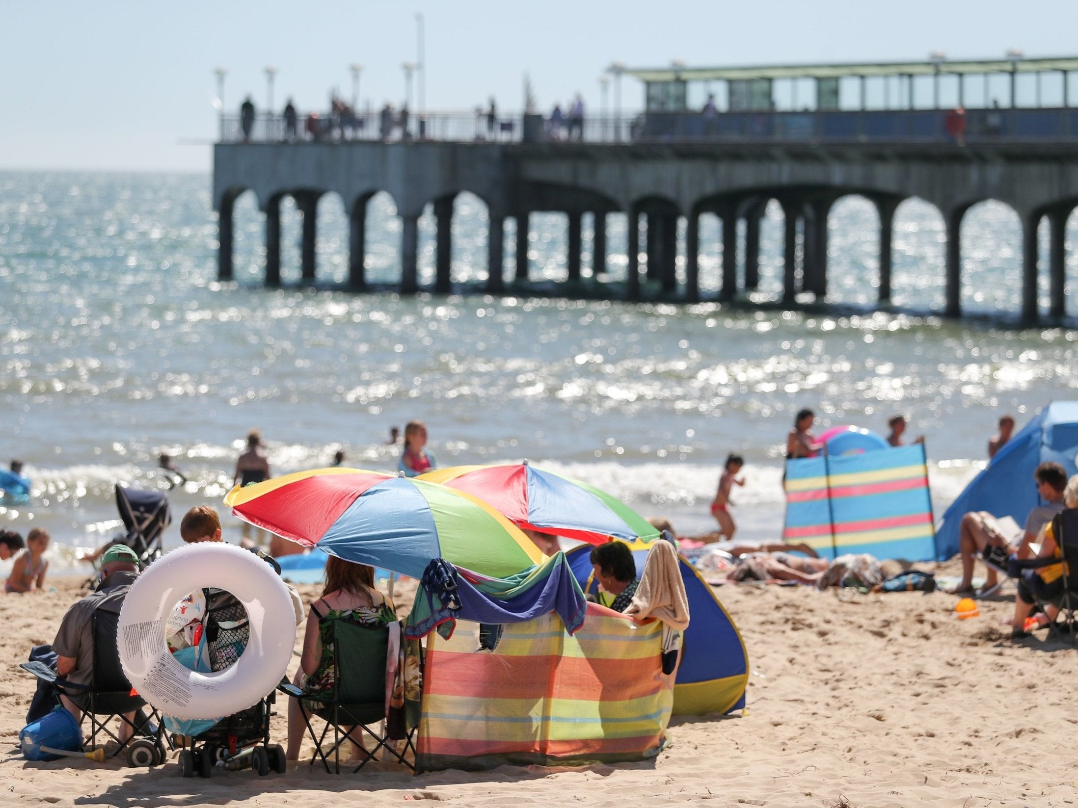 People enjoy the warm weather on Boscombe beach in Dorset. The RNLI has urged swimmers to use lifeguarded beaches during hot weather this weekend