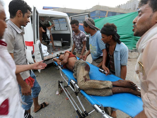 Volunteers rush a man to an ambulance after he was injured by an airstrike on a fish market in Hodeidah