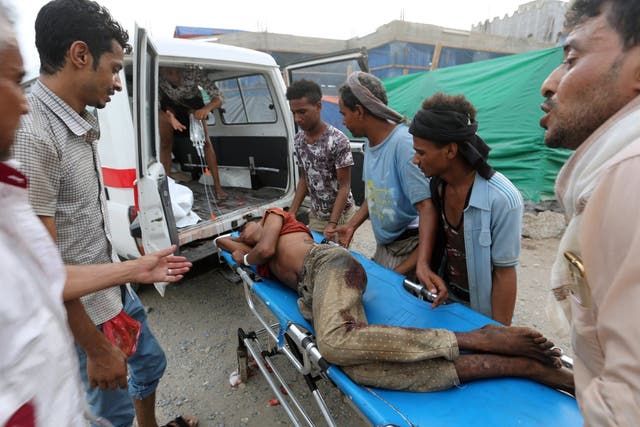Volunteers rush a man to an ambulance after he was injured by an airstrike on a fish market in Hodeidah