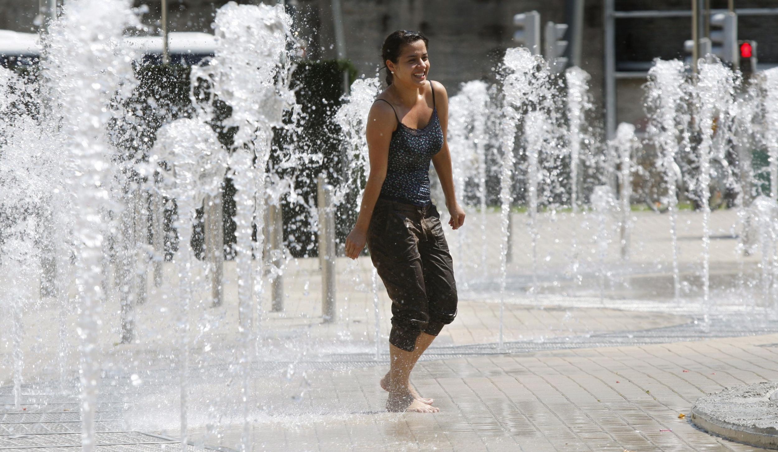 A girl takes a cooling dip in Abandoibarra Park in Bilbao