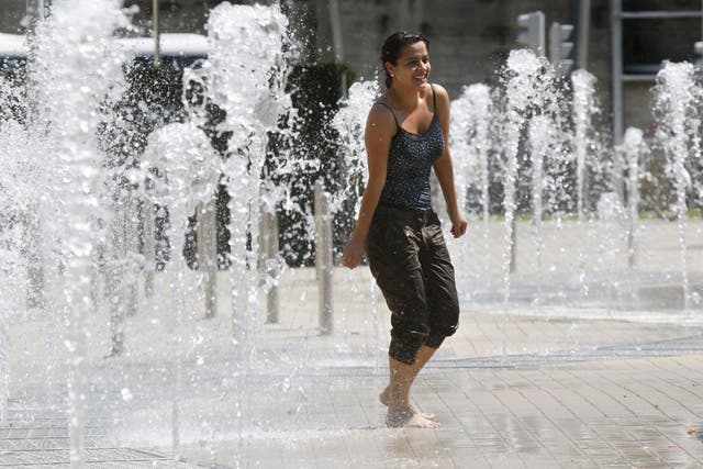 A girl takes a cooling dip in Abandoibarra Park in Bilbao