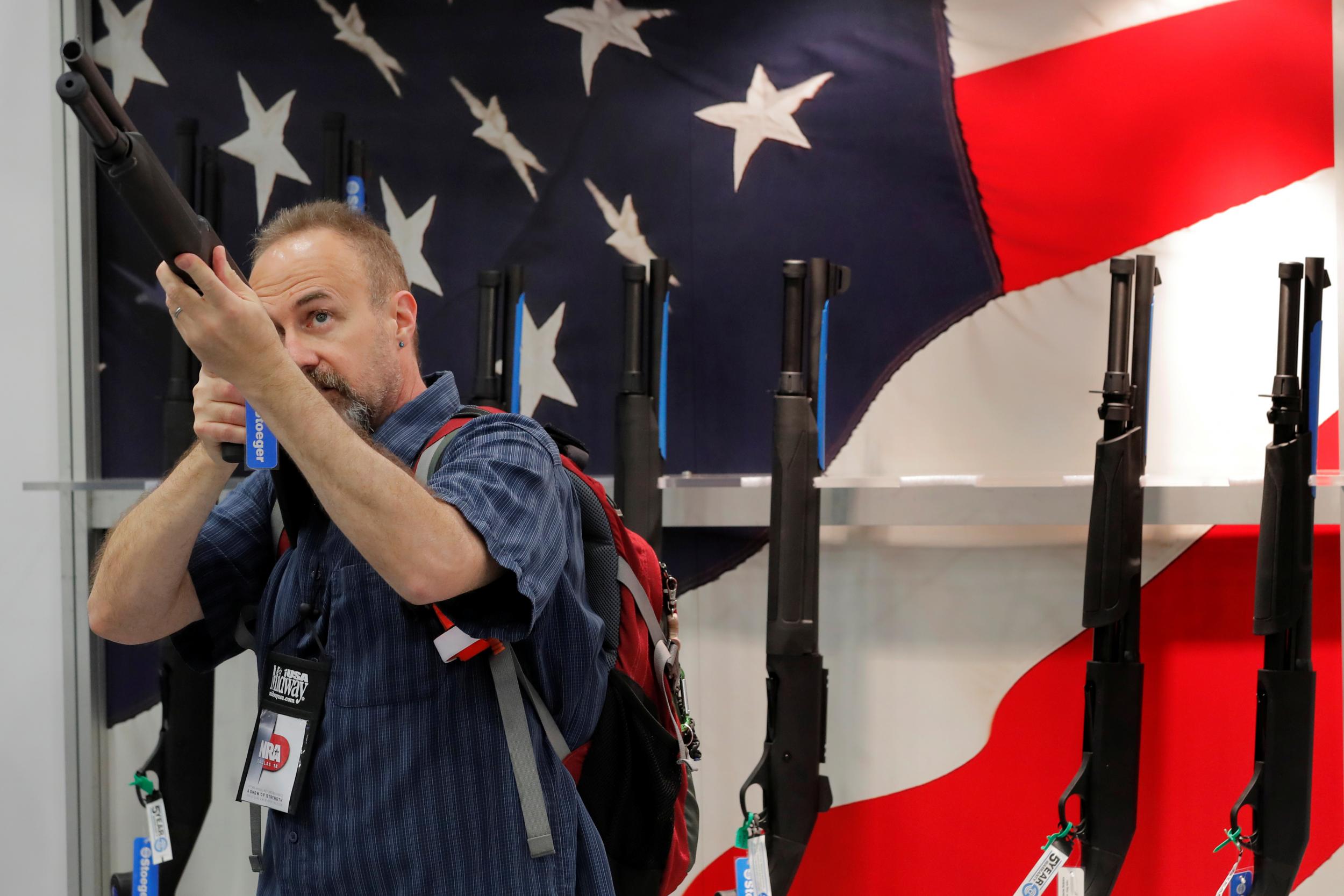 A gun enthusiast looks at a shotgun during the annual National Rifle Association (NRA) convention in Dallas, Texas, U.S., May 5, 2018.