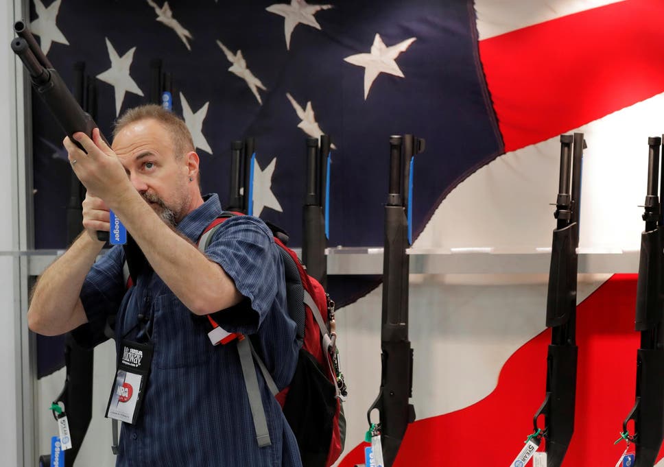 A gun enthusiast looks at a shotgun during the annual National Rifle Association (NRA) convention in Dallas, Texas, U.S., May 5, 2018.