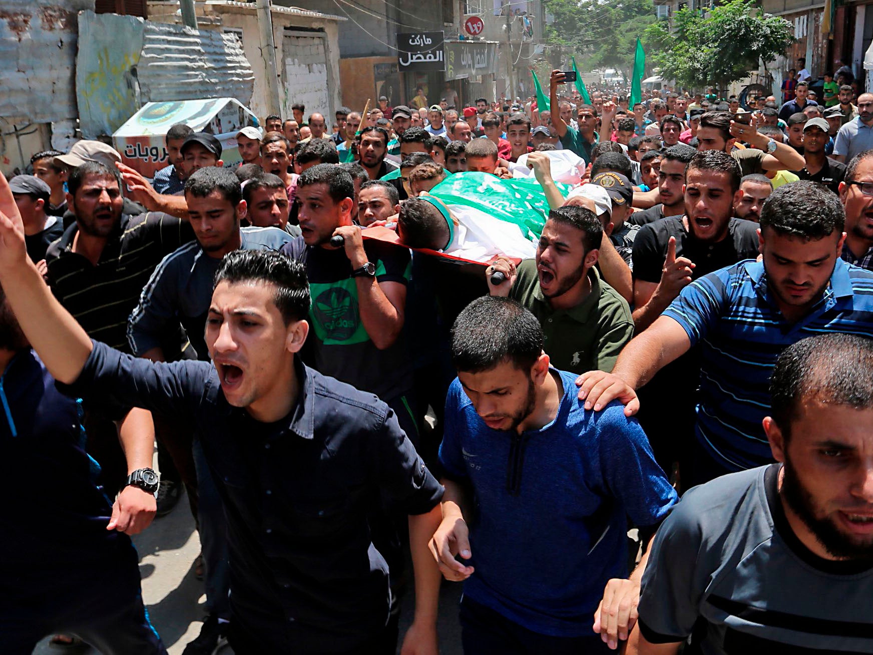 Palestinian mourners carry the body of Muadh al-Suri, aged 15, who was killed in clashes with Israeli forces the day before, during his funeral in Nuseirat camp, in central Gaza Strip, on August 4, 2018