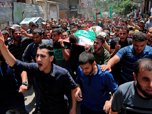 Palestinian mourners carry the body of Muadh al-Suri, aged 15, who was killed in clashes with Israeli forces the day before, during his funeral in Nuseirat camp, in central Gaza Strip, on August 4, 2018