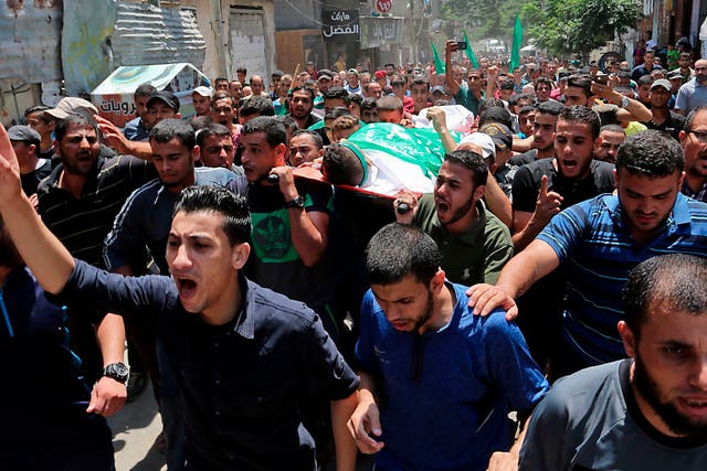 Palestinian mourners carry the body of Muadh al-Suri, aged 15, who was killed in clashes with Israeli forces the day before, during his funeral in Nuseirat camp, in central Gaza Strip, on August 4, 2018