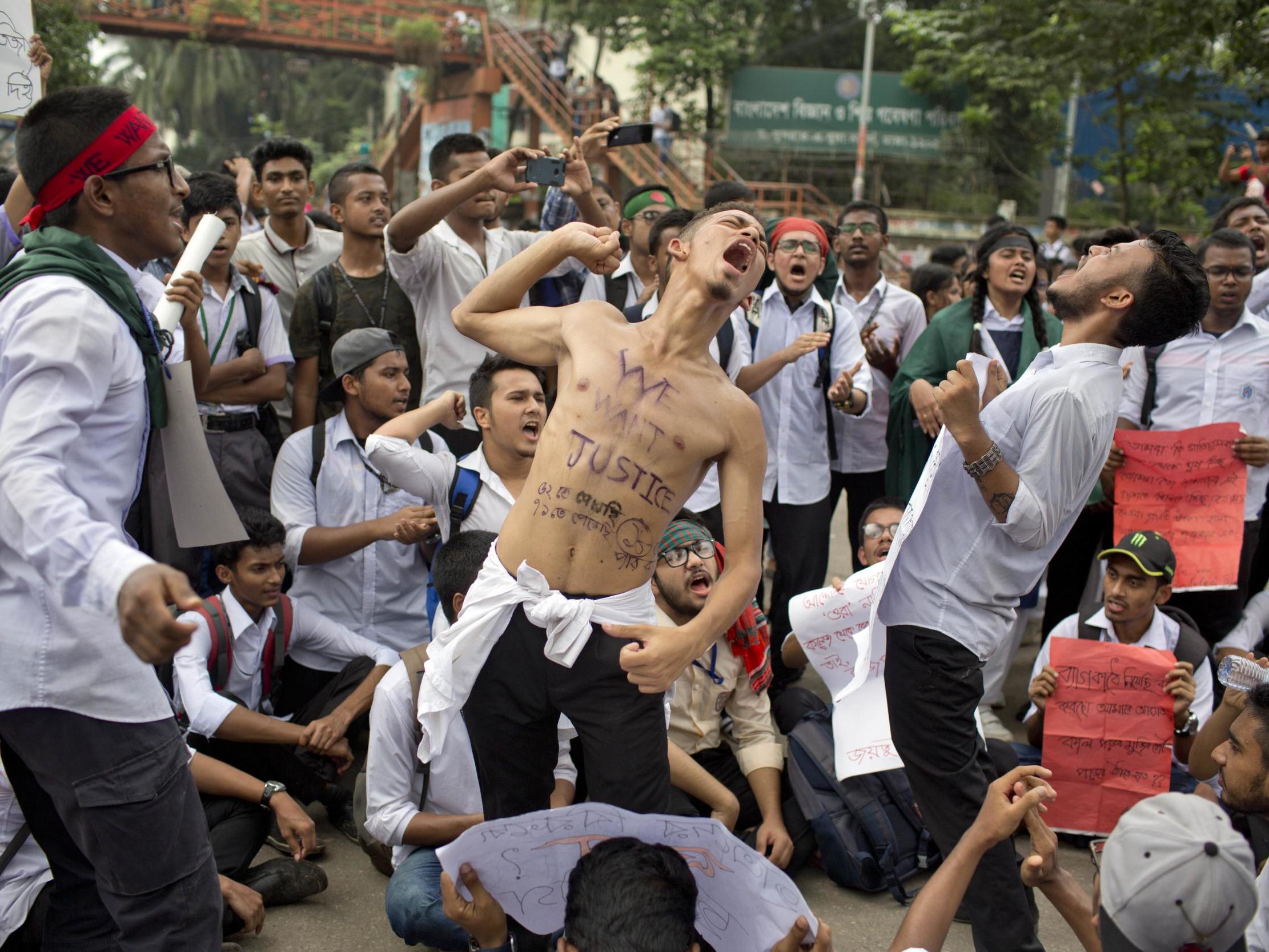 Students shout slogans and block a road during a protest following two people's deaths