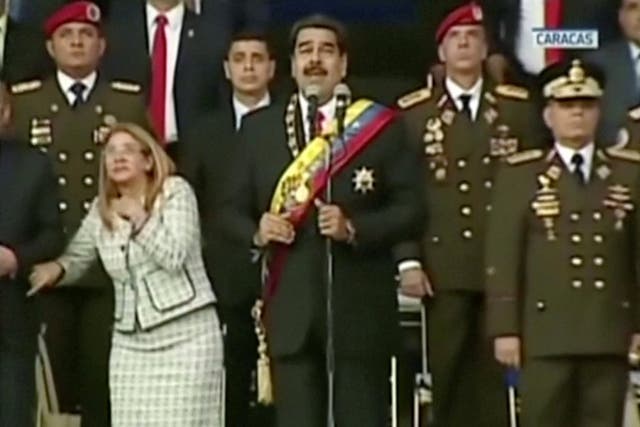 Venezuelan President Nicolas Maduro and his wife Cilia Flores look startled during his speech in the country's capital, Caracas.
