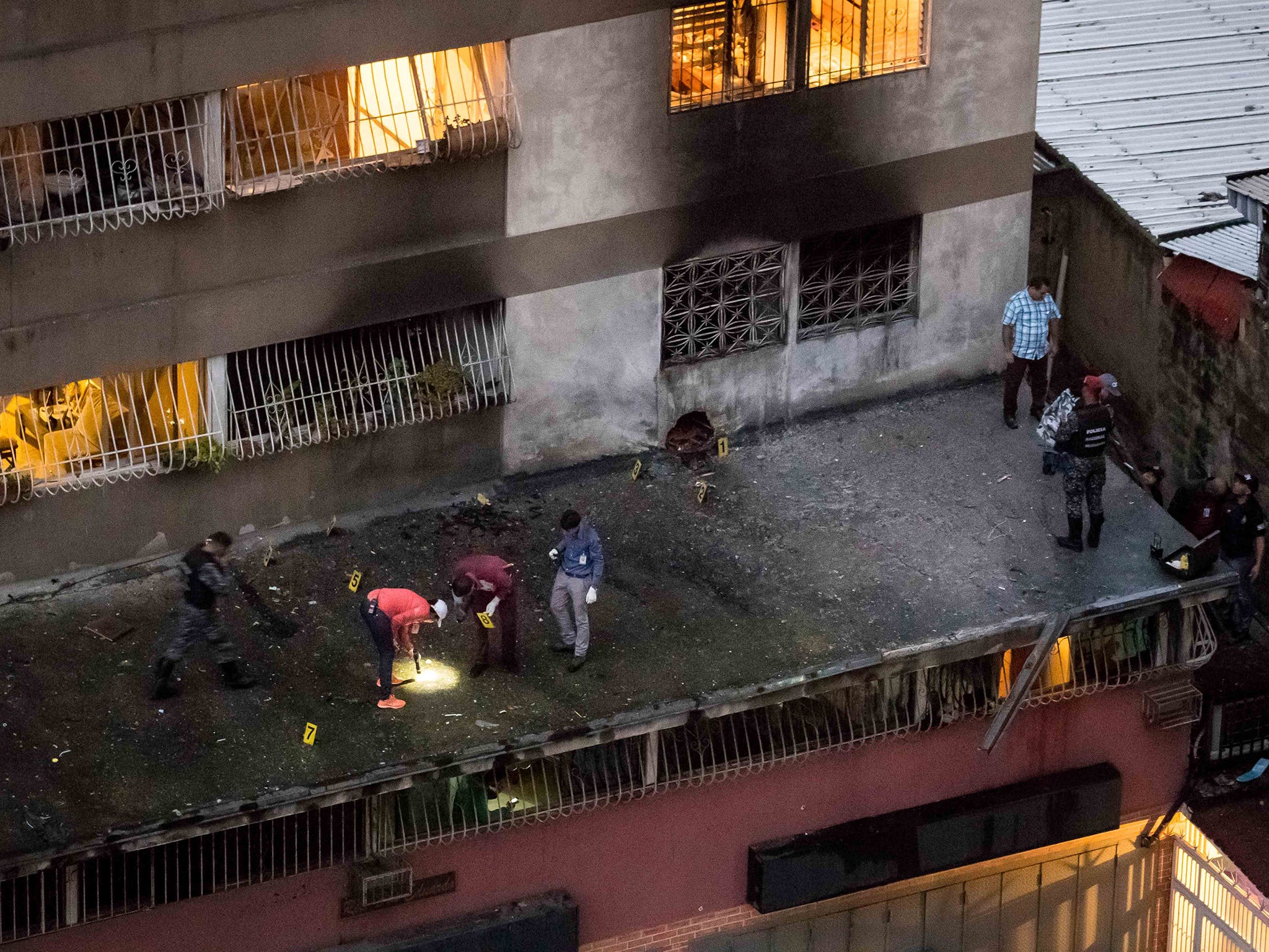 Security forces take evidence after an explosion via drone targeted Venezuelan President Nicolas Maduro in Caracas