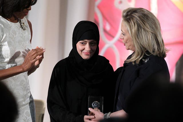 Arrested Saudi activist Samar al Badawi (C) with Michelle Obama (L) and Hillary Clinton (R) during a ceremony at the US state department on 8 March 2012 in Washington DC