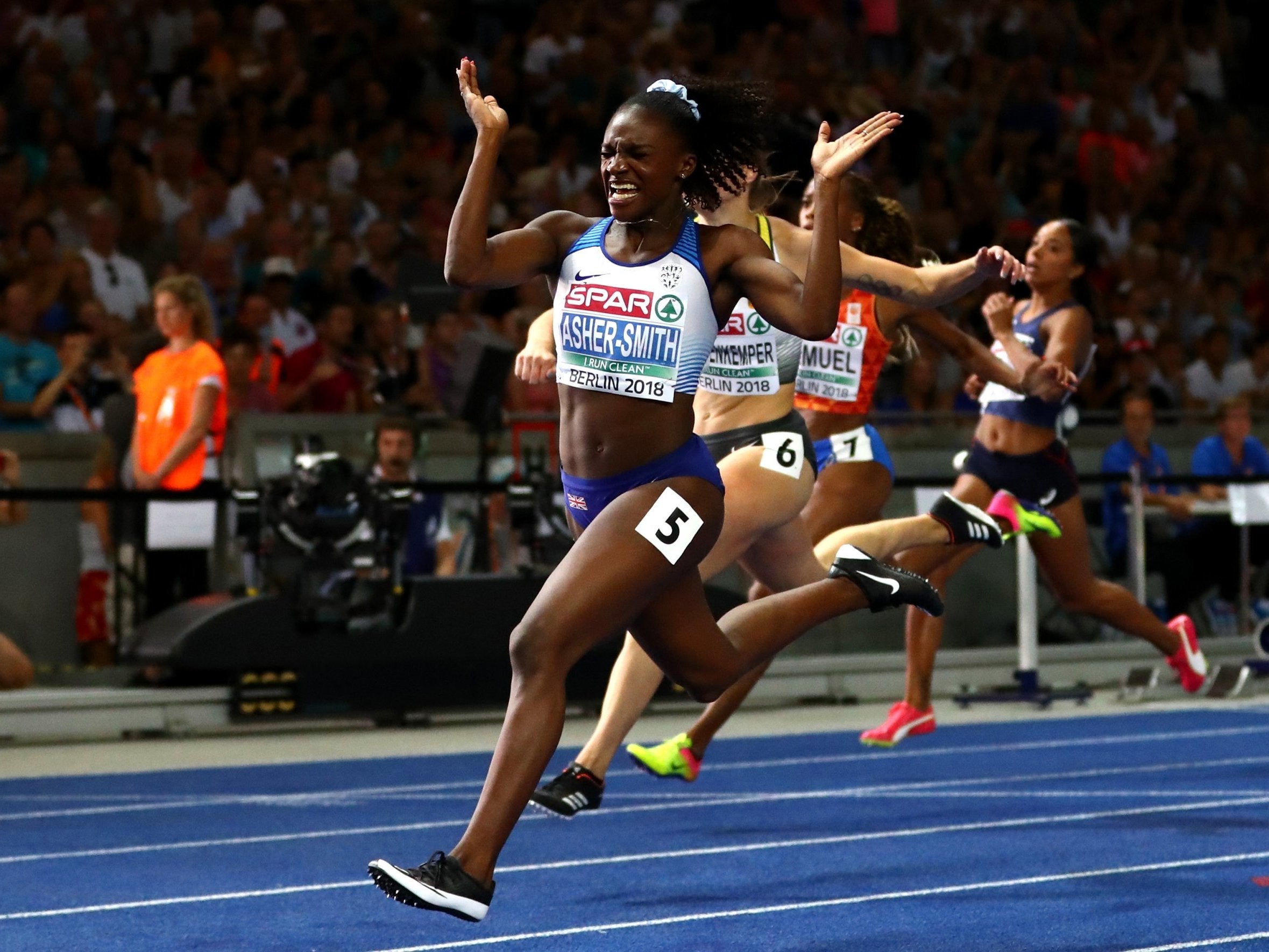 Dina Asher-Smith celebrates as she crosses the line