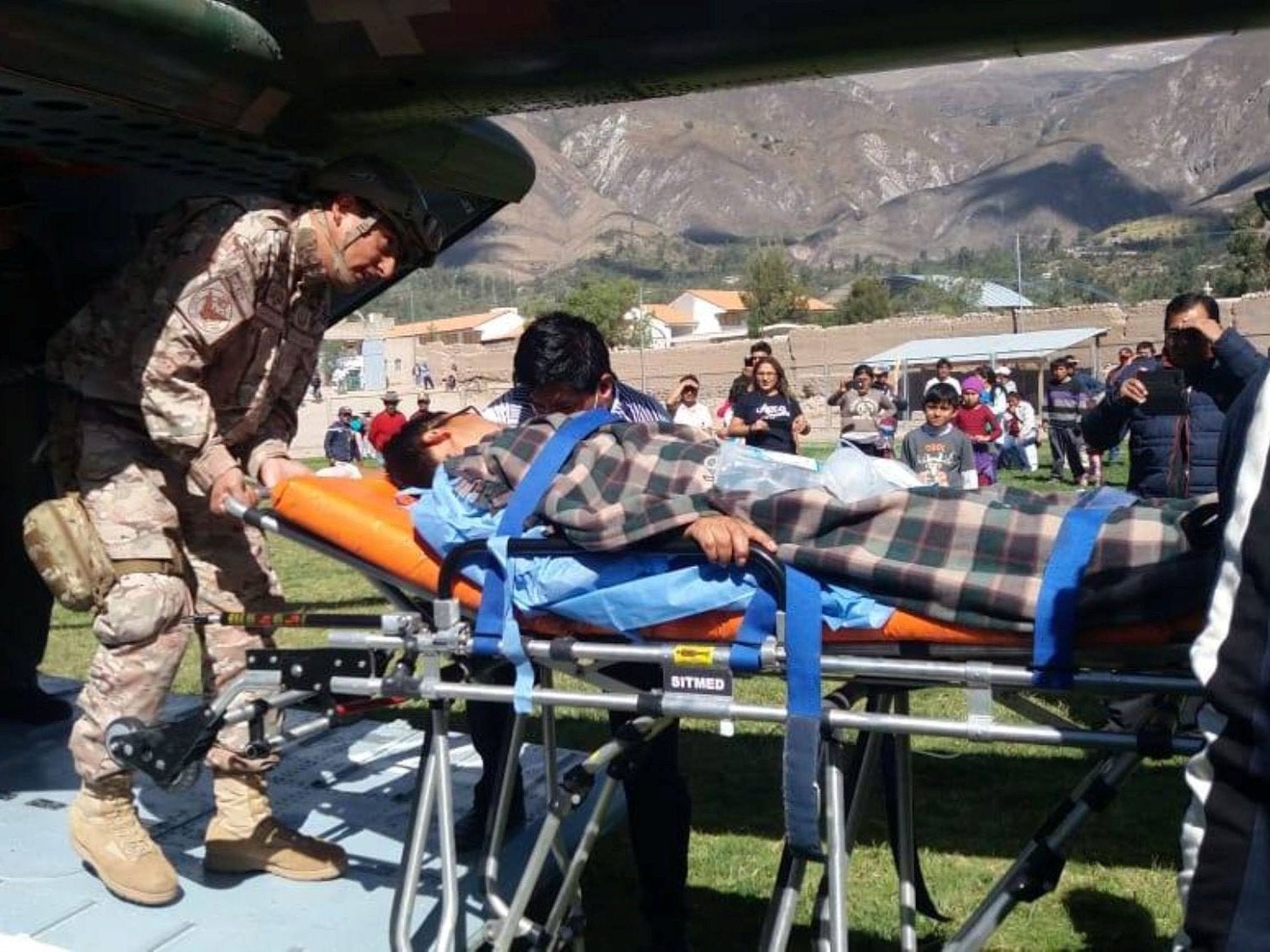 A person is transported to a helicopter after eating contaminated food at a funeral in the Peruvian Andes