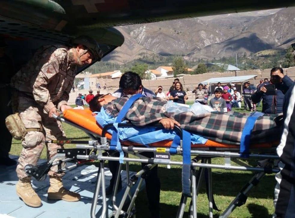 A person is transported to a helicopter after eating contaminated food at a funeral in the Peruvian Andes
