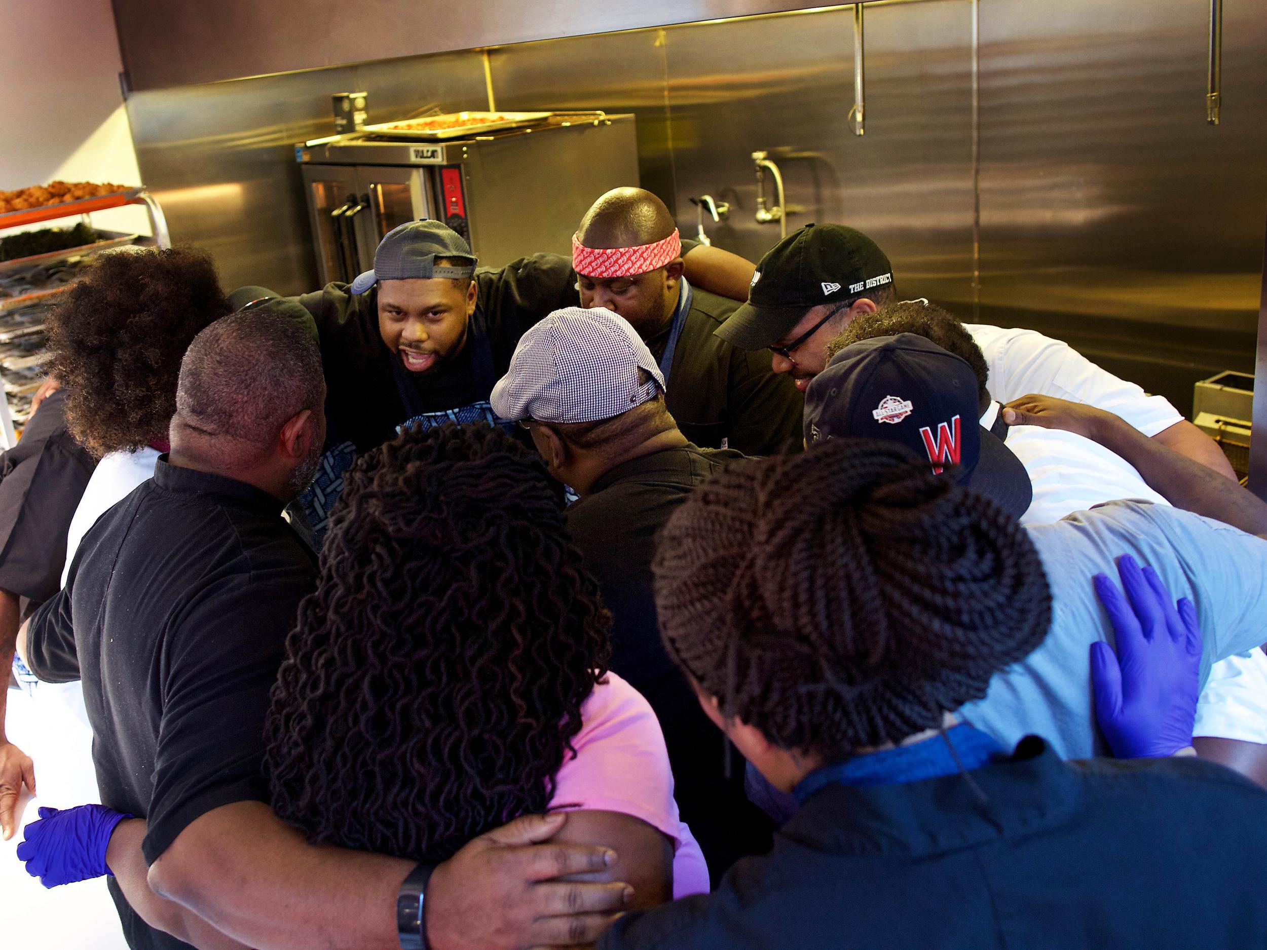 Greg Collier (centre) leads the Soul Food Sessions chefs in a moment of solidarity before the plating begins