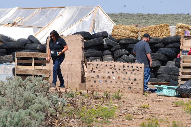 Taos County Planning Department officials Rachel Romero, left, and Eric Montoya survey property conditions at a disheveled living compound at Amalia, N.M., on Tuesday, Aug. 7, 2018.