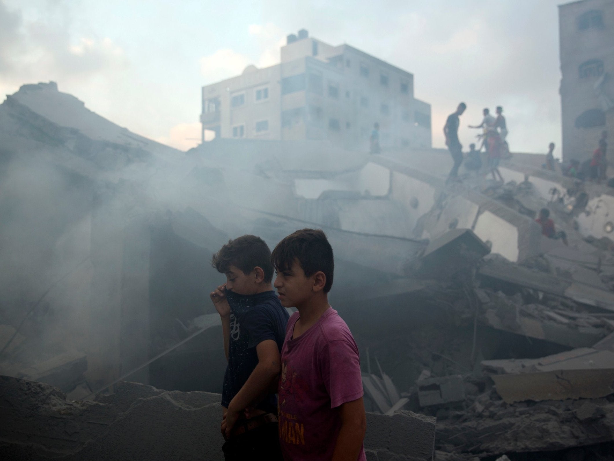 Palestinians inspect the damaged building of the Said al-Mis’hal cultural centre after it was hit by an Israeli airstrike in Gaza