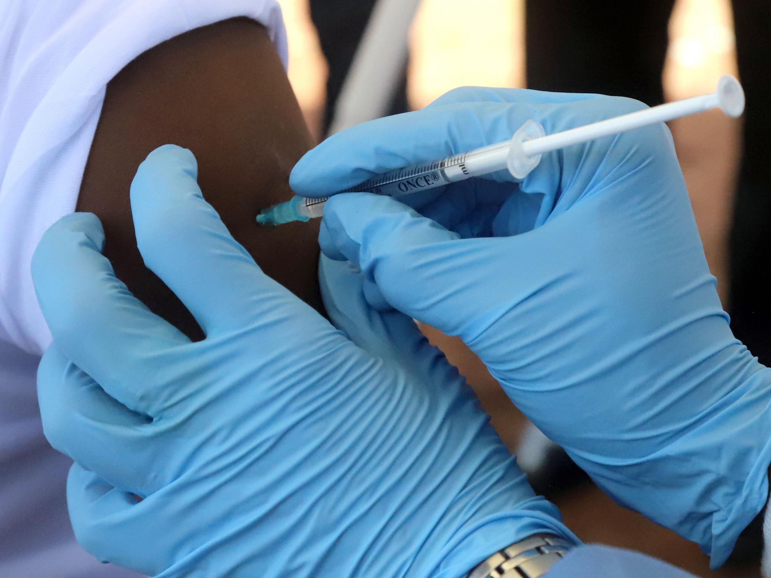 A World Health Organization (WHO) worker administers a vaccination during the launch of a campaign aimed at beating an outbreak of Ebola in the port city of Mbandaka, Democratic Republic of Congo May 21, 2018